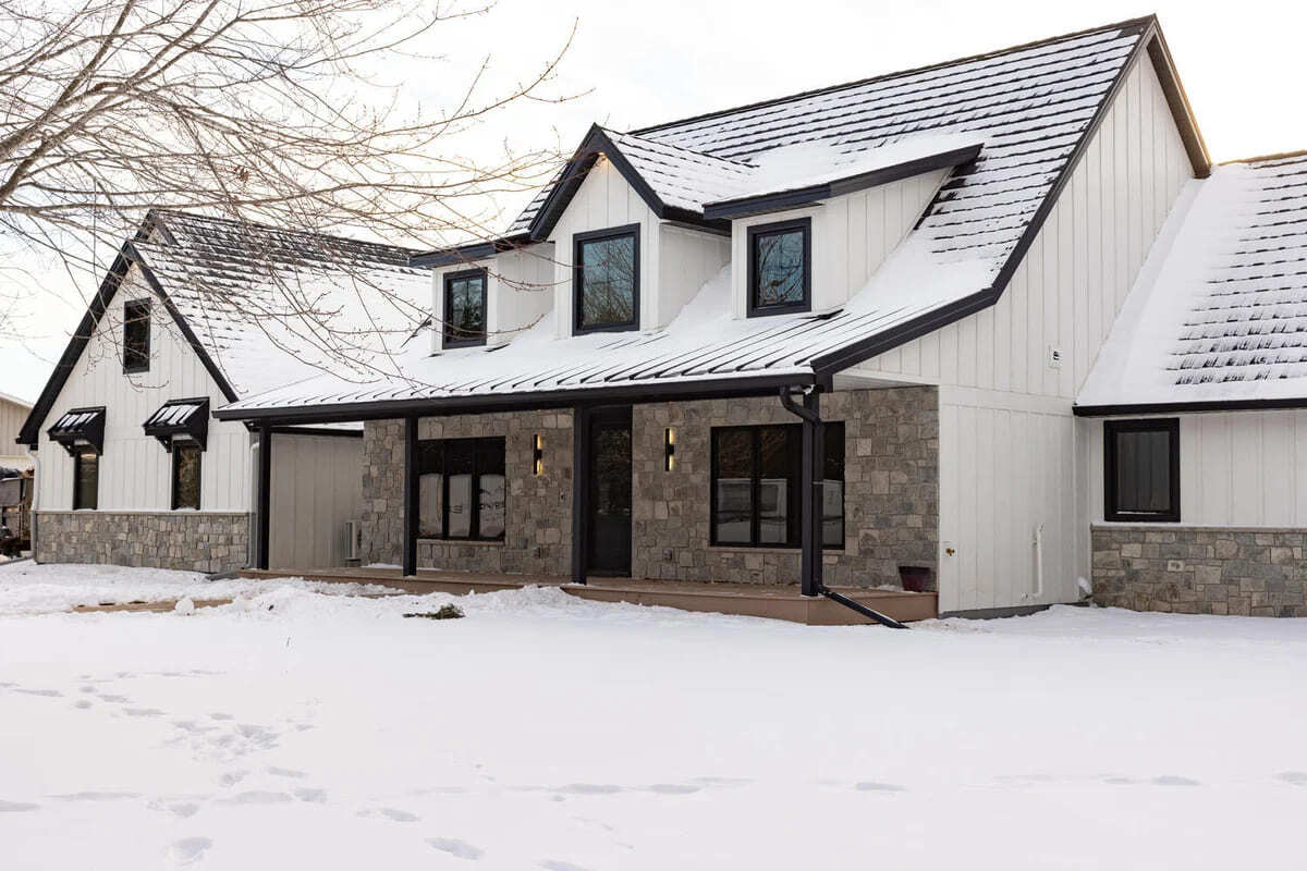 Wide-angle exterior of a custom home by Ross Construction in Rib Mountain, WI, with snow-covered roof.
