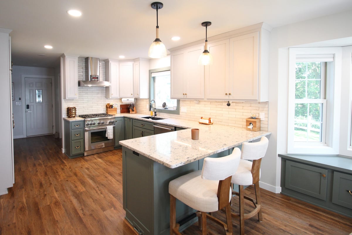 Open concept kitchen with island lighting and wood flooring in Marathon home by Ross Construction.
