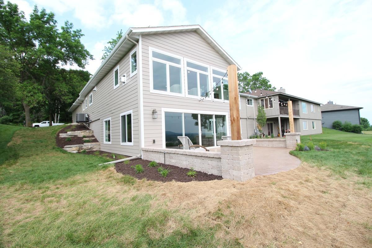 Angled view of custom home exterior with terraced landscaping and large windows in Rib Mountain, WI by Ross Construction
