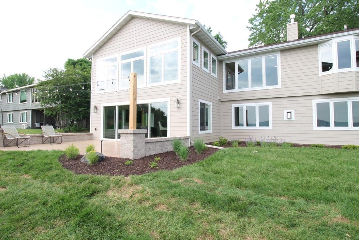 Beautiful exterior renovation featuring large windows and walk-out patio by Ross Construction in Wausau, WI