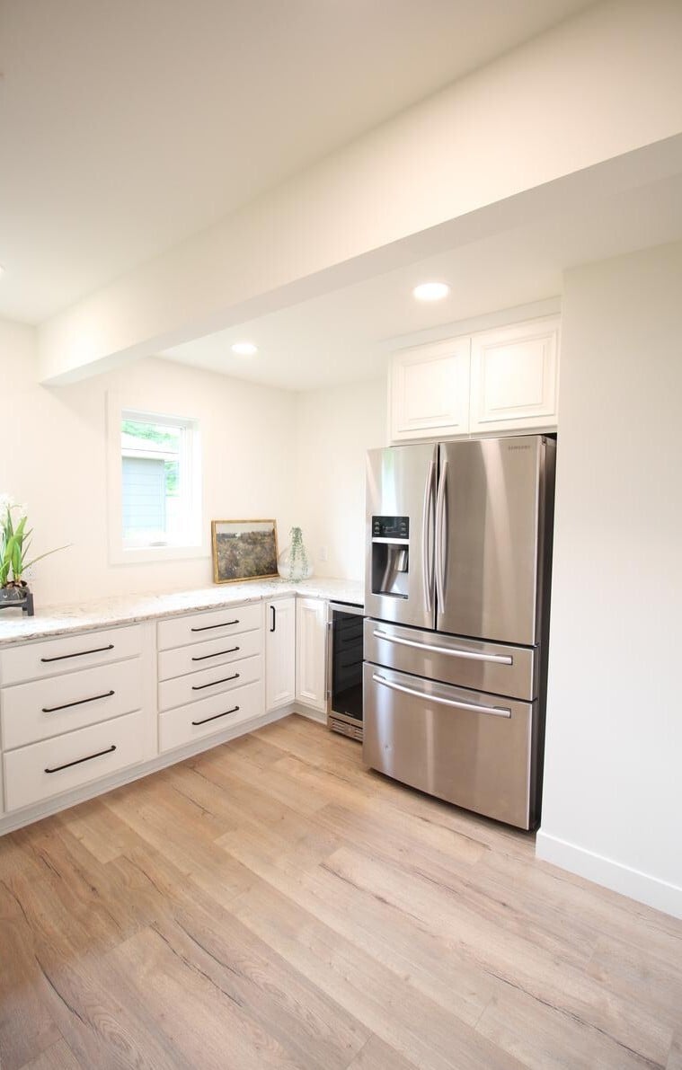 Bright corner kitchen in a Ross Construction custom home featuring stainless appliances in Marathon, WI.
