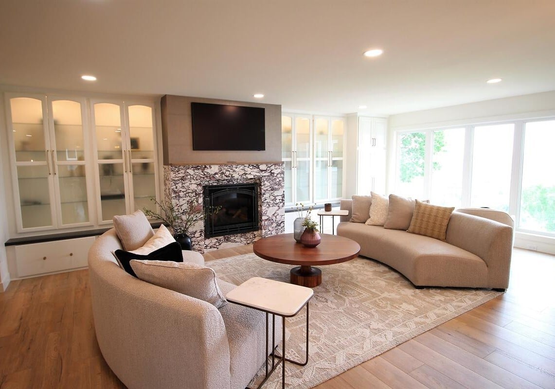 Curved sofa seating around a fireplace in a Ross Construction custom home living room in Wausau, WI.
