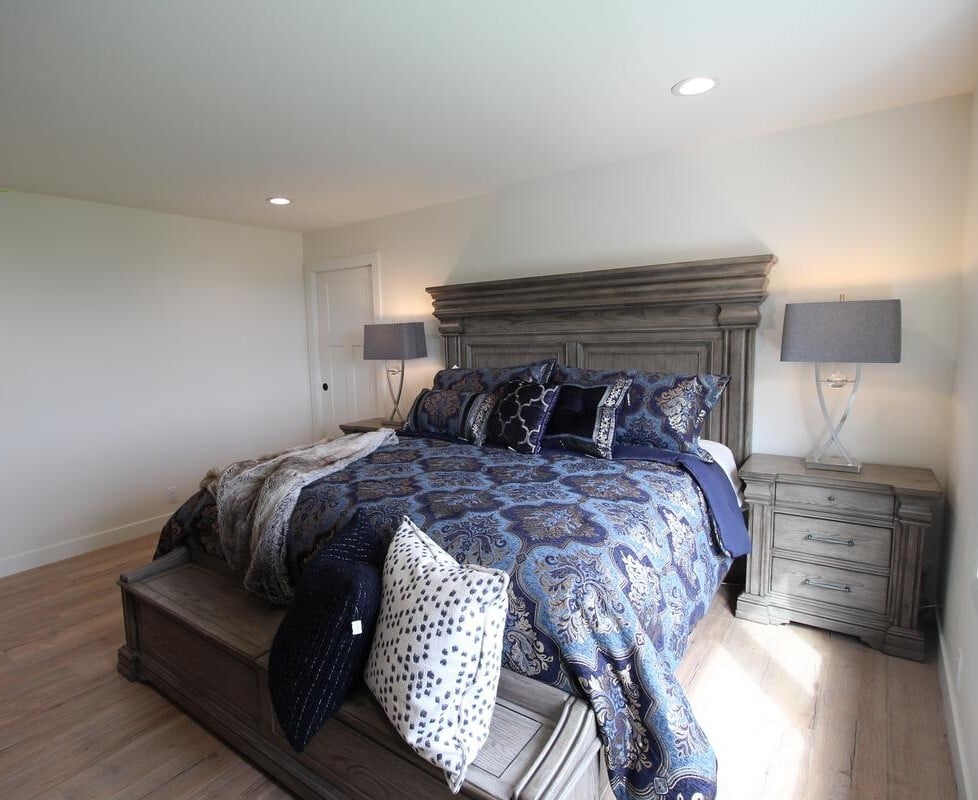 Master bedroom with wood furnishings and rich bedding in a Ross Construction custom home in Rib Mountain, WI.