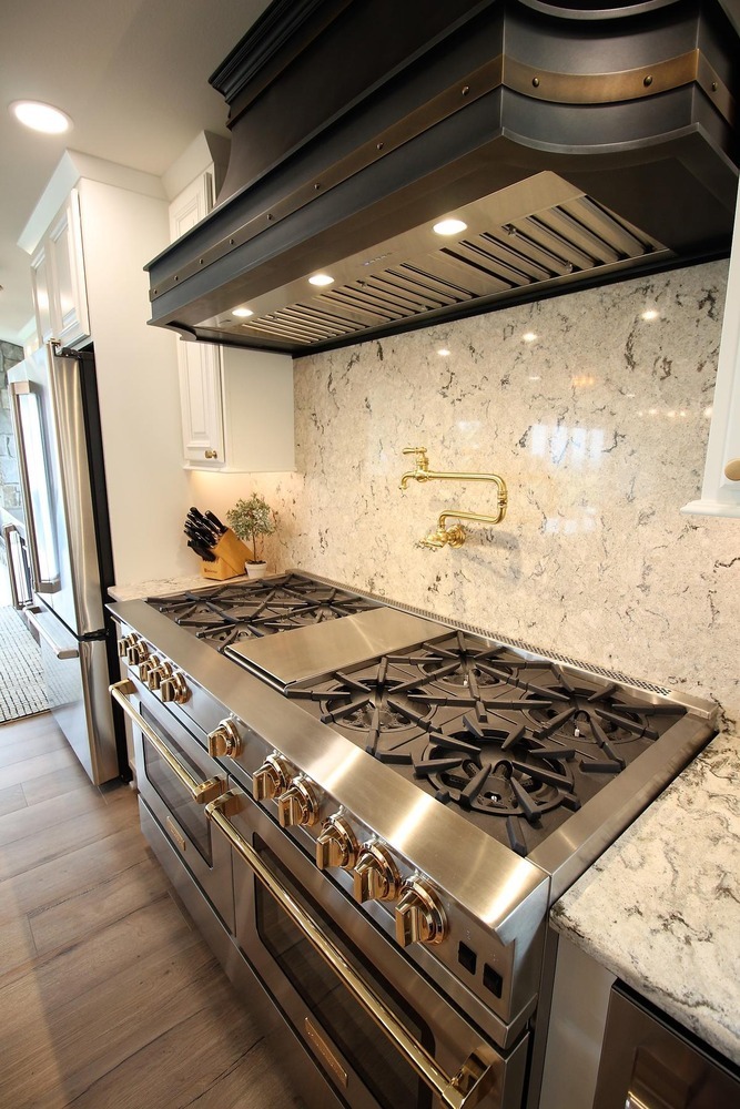 Professional-grade gas range and hood in a custom Ross Construction kitchen in Rib Mountain, WI.