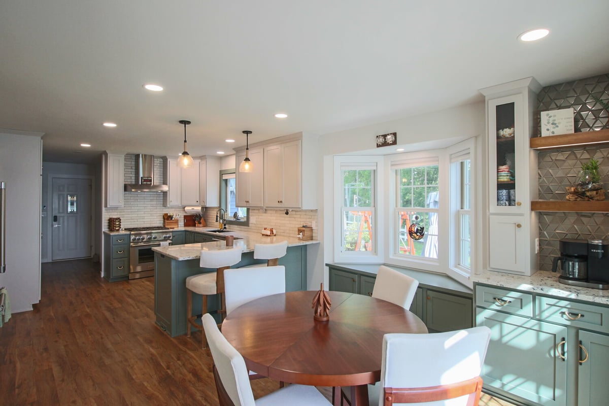 Custom kitchen and dining remodel in Marathon, WI home by Ross Construction with bay window and island seating.