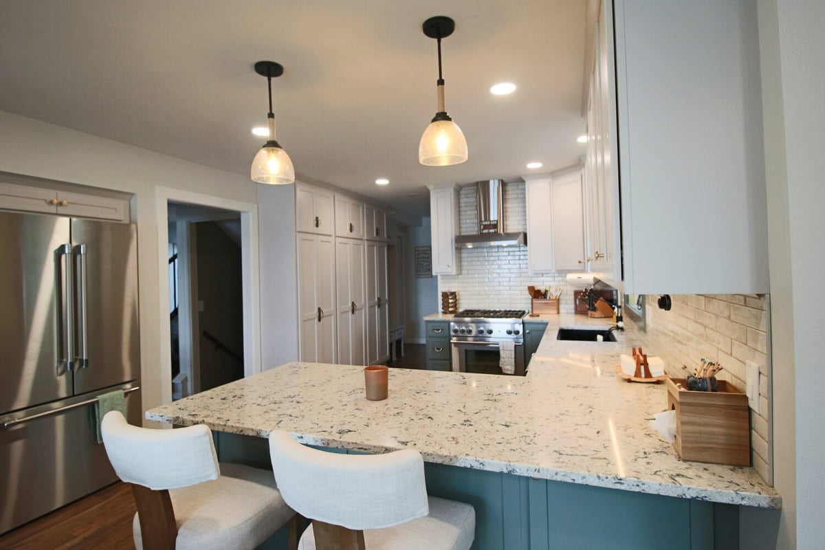 Light granite countertops and island seating in custom Marathon kitchen by Ross Construction.