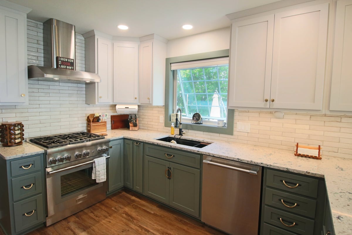 Marathon kitchen remodel by Ross Construction with green cabinets, white uppers, and a stainless range.