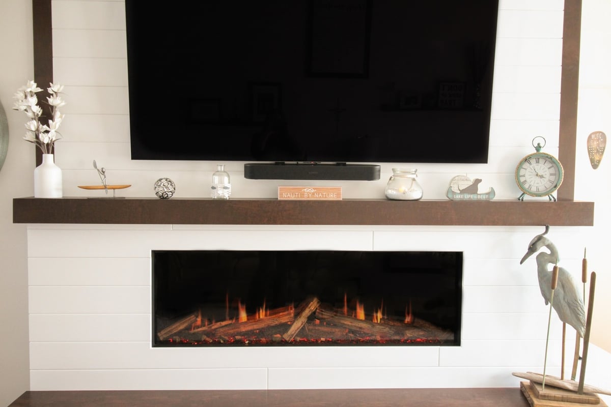 Shiplap fireplace wall with TV and decorative mantel in Marathon custom home by Ross Construction.