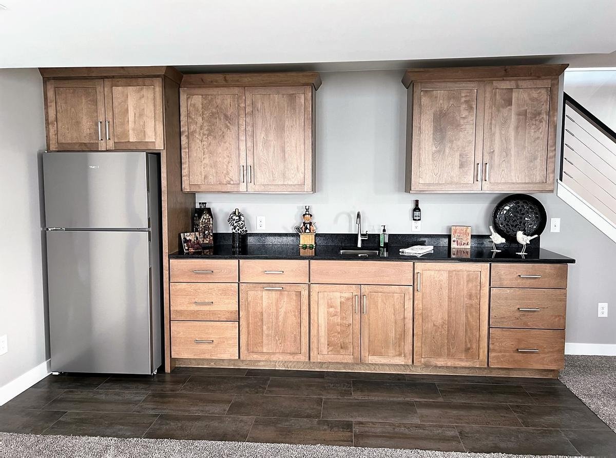 Basement wet bar with natural wood cabinetry in Wausau custom home by Ross Construction.