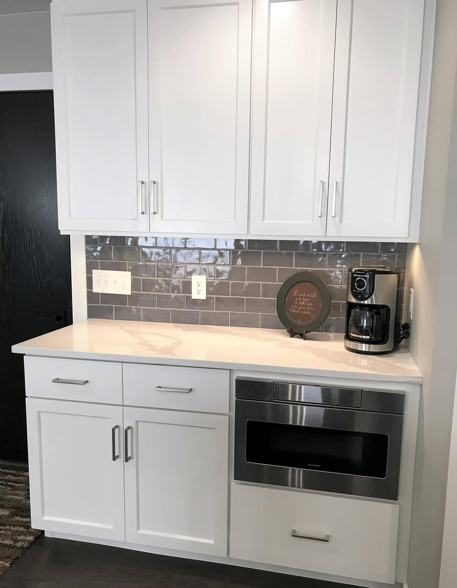Microwave drawer built into white kitchen cabinetry in Marathon home by Ross Construction.