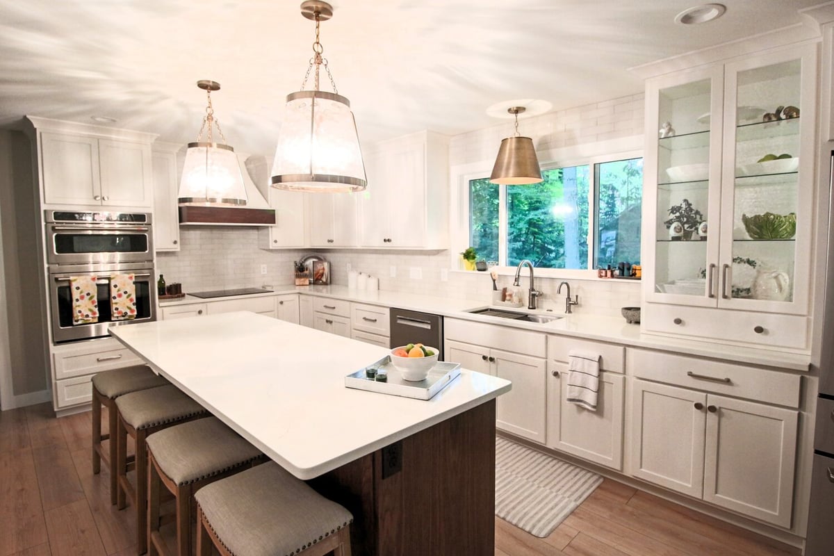 White kitchen with oversized windows and pendant lights in a Ross Construction custom home in Wausau, WI.