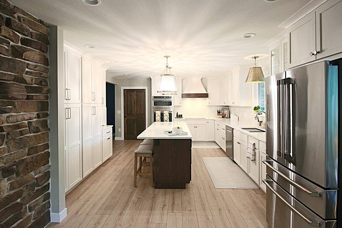 Wide-angle kitchen shot with stainless appliances and large island by Ross Construction in Marathon, WI.