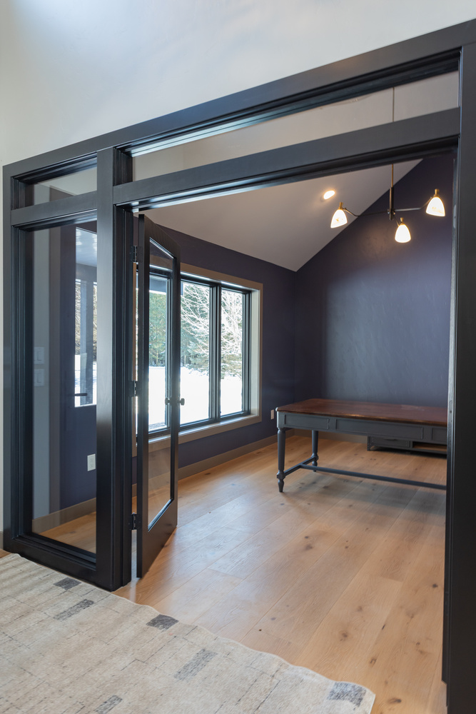 Custom-designed office space with navy accent wall and wood floors by Ross Construction in Rib Mountain, WI.