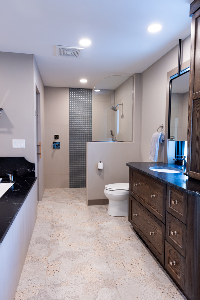 Elegant primary bathroom with tile flooring and glass shower in Lake Dubay, WI custom home by Ross Construction.