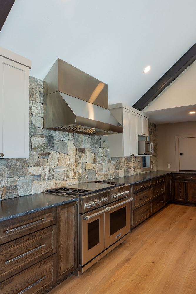 Gourmet kitchen with dual oven and stone backsplash in custom home by Ross Construction in Wausau, WI.