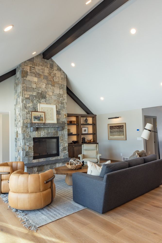 Ross Construction-designed open-concept living space in Marathon, WI featuring leather seating and stone accents.