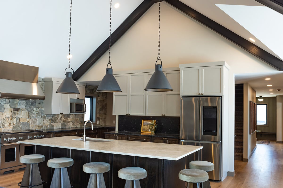Spacious kitchen with cathedral ceiling and large island in custom home by Ross Construction in Marathon, WI.
