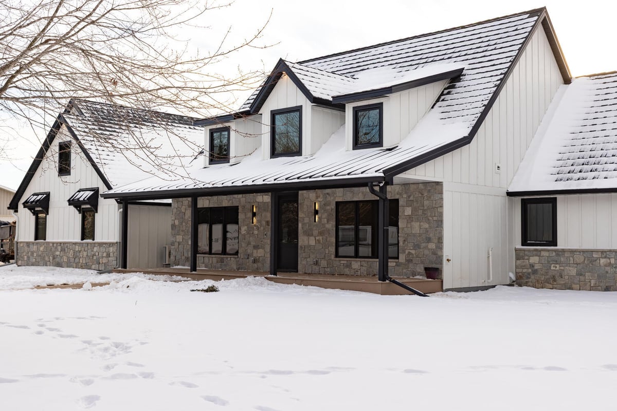 Wide-angle exterior of a custom home by Ross Construction in Rib Mountain, WI, with snow-covered roof.