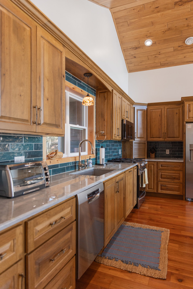 Custom kitchen with natural wood cabinets and ceiling by Ross Construction in Lake Dubay, WI.