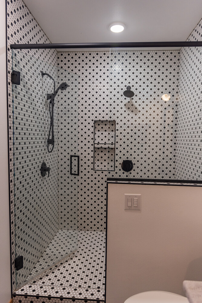 Modern custom shower with mosaic tile and matte black fixtures in Rib Mountain, WI home by Ross Construction.