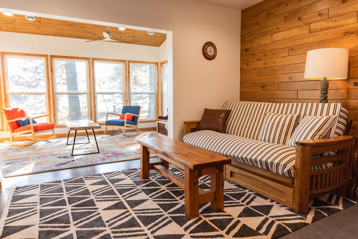 Open transition from living room to sunroom with natural light by Ross Construction in Marathon, WI.
