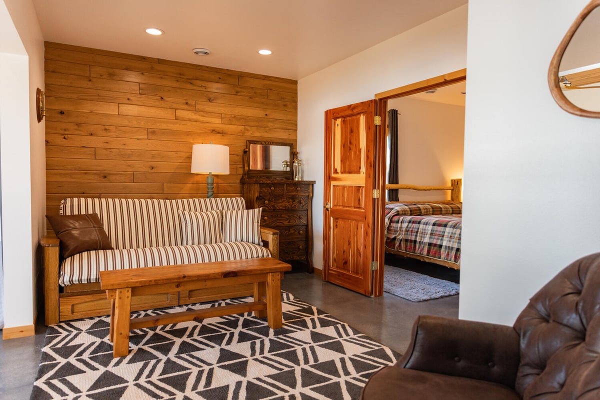 Rustic lounge space with wood accent wall and futon by Ross Construction in Lake Dubay, WI.