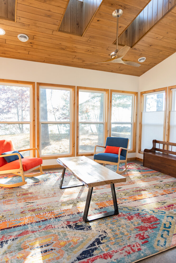 Sunroom with vaulted wood ceiling and full-height windows by Ross Construction in Marathon, WI.