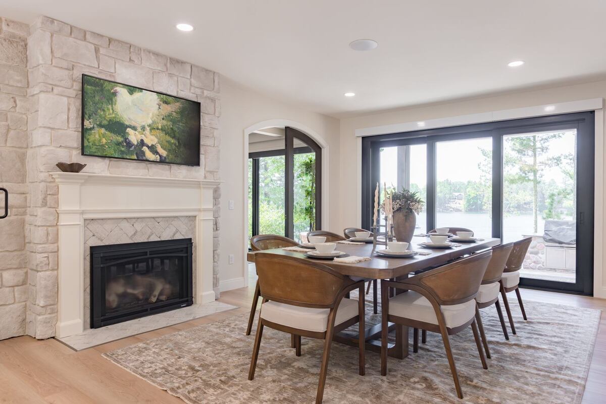 whole home remodel dining room with stone fireplace and lake view minocqua wi