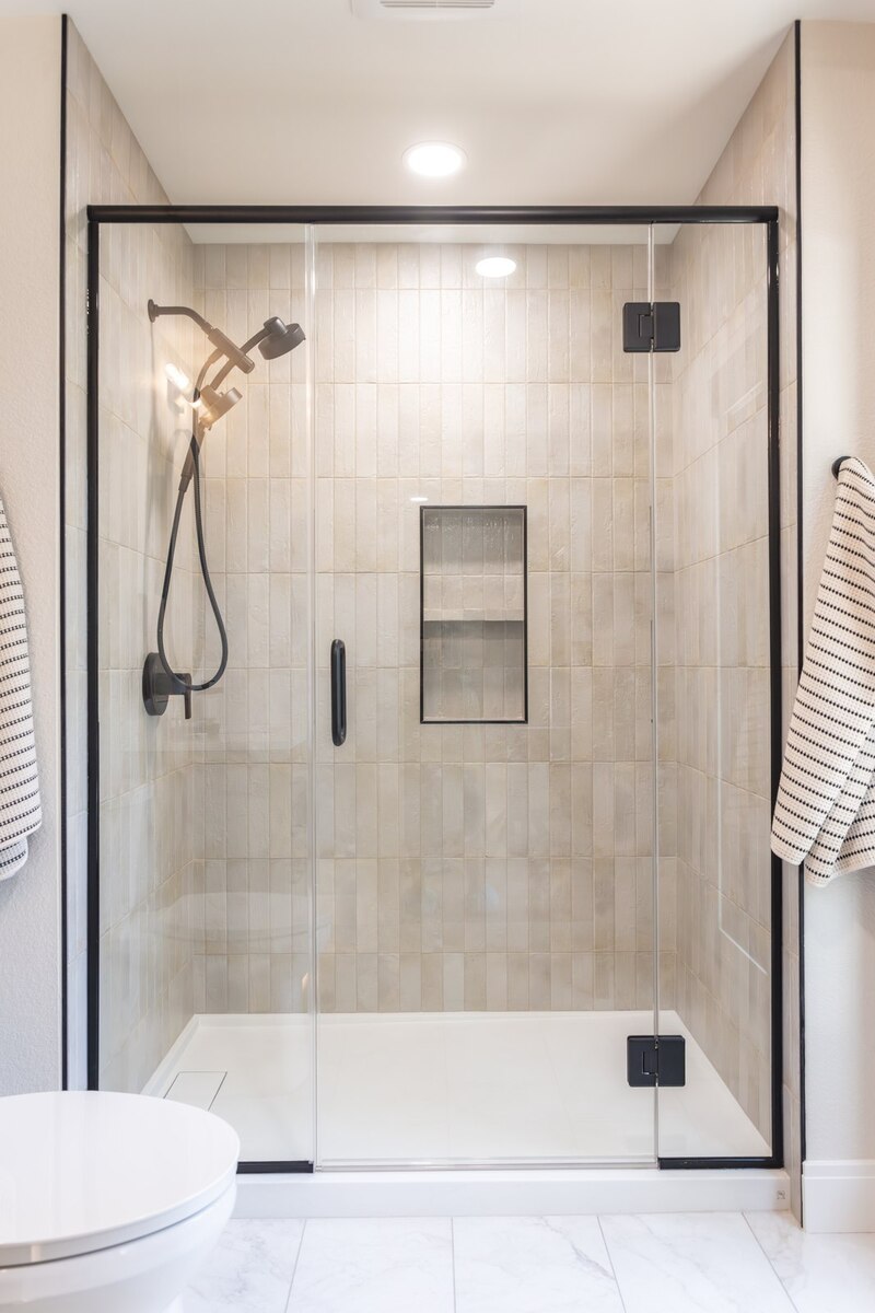 whole home remodel guest bathroom shower with black glass enclosure minocqua wi
