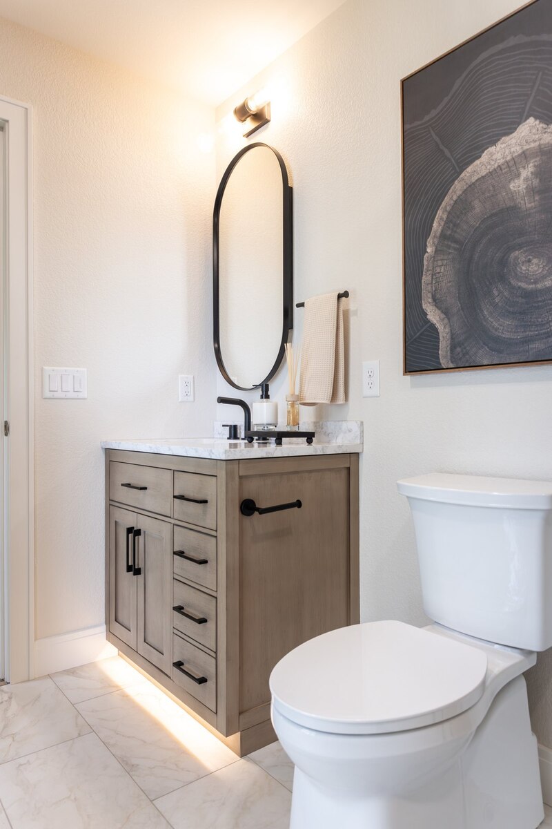 whole home remodel guest bathroom vanity with oval mirror and toe kick lighting minocqua wi