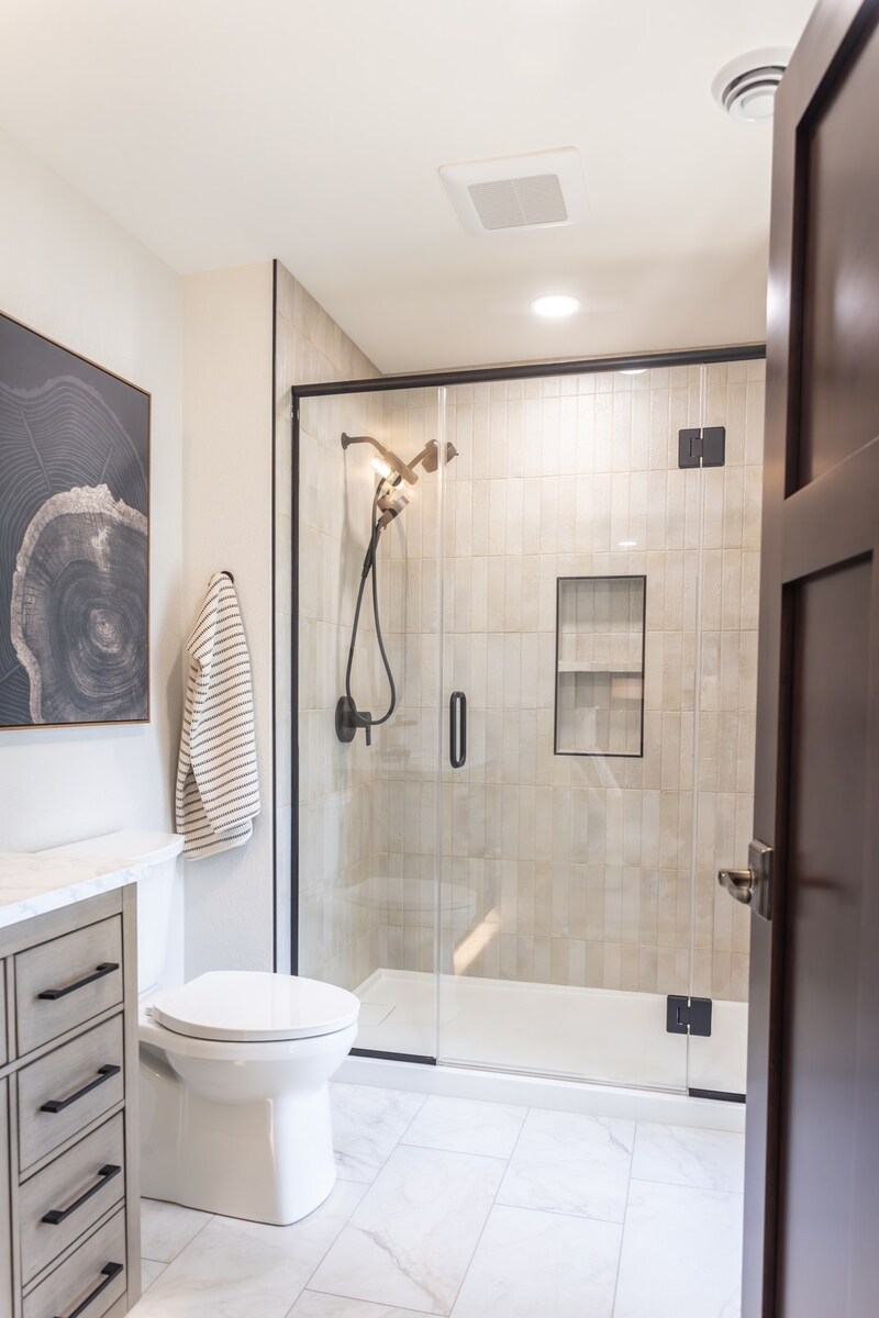 whole home remodel guest bathroom with glass shower and tree ring art minocqua wi