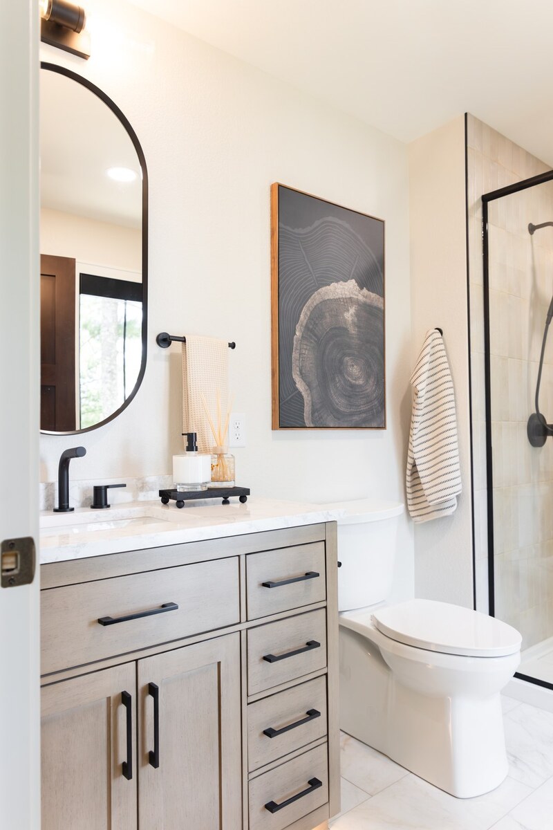 whole home remodel guest bathroom with gray vanity and black fixtures minocqua wi