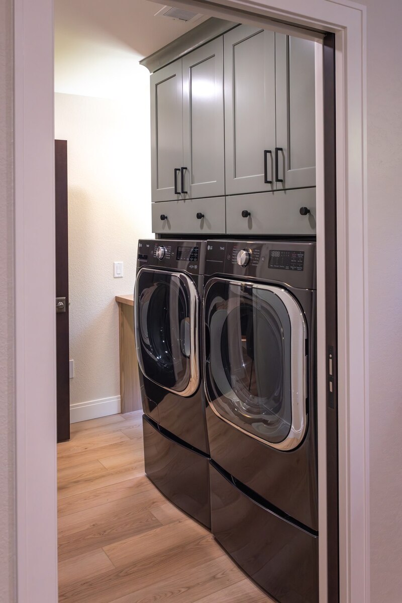 whole home remodel laundry room with sage green cabinets minocqua wi