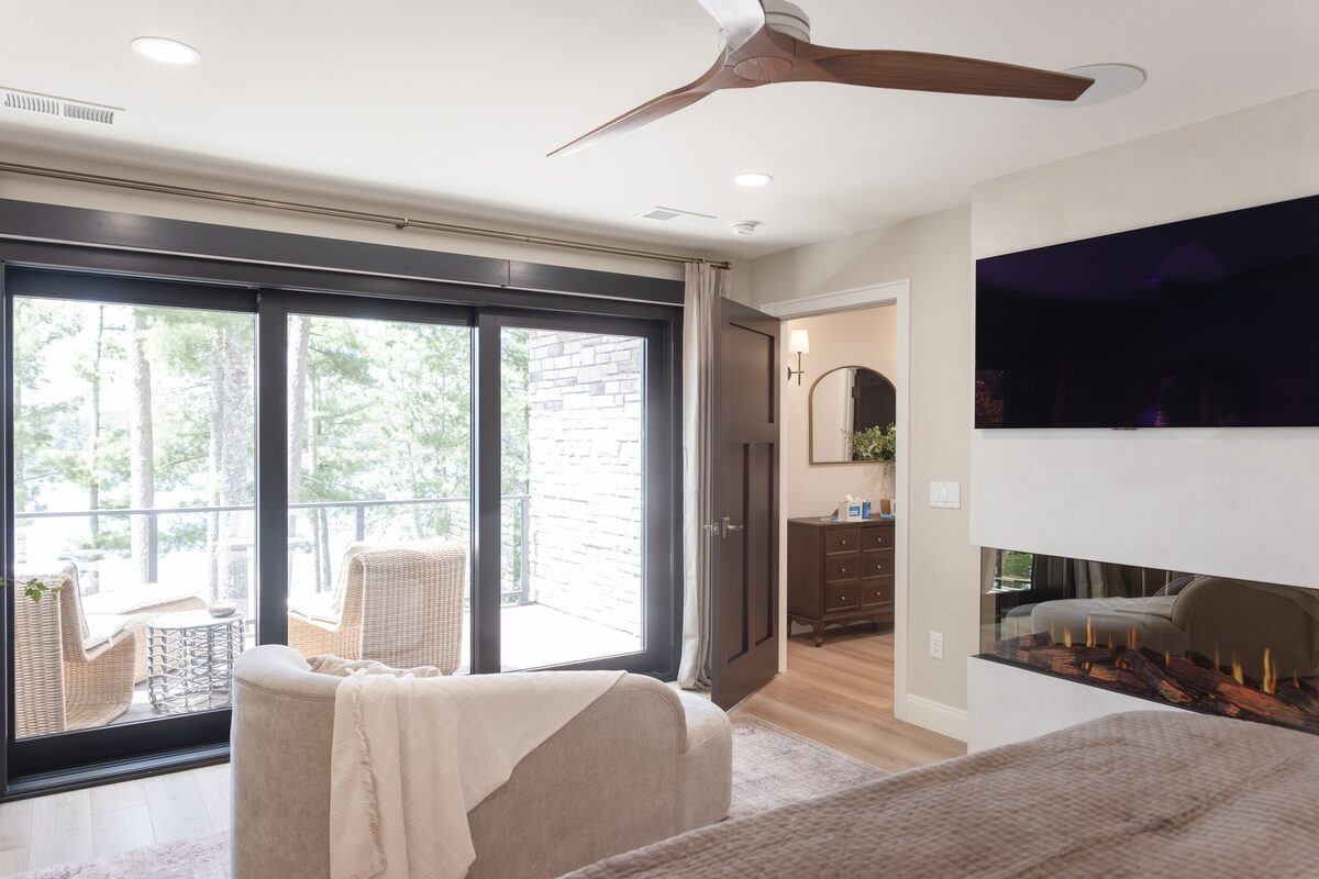 whole home remodel primary bedroom with fireplace and balcony access minocqua wi