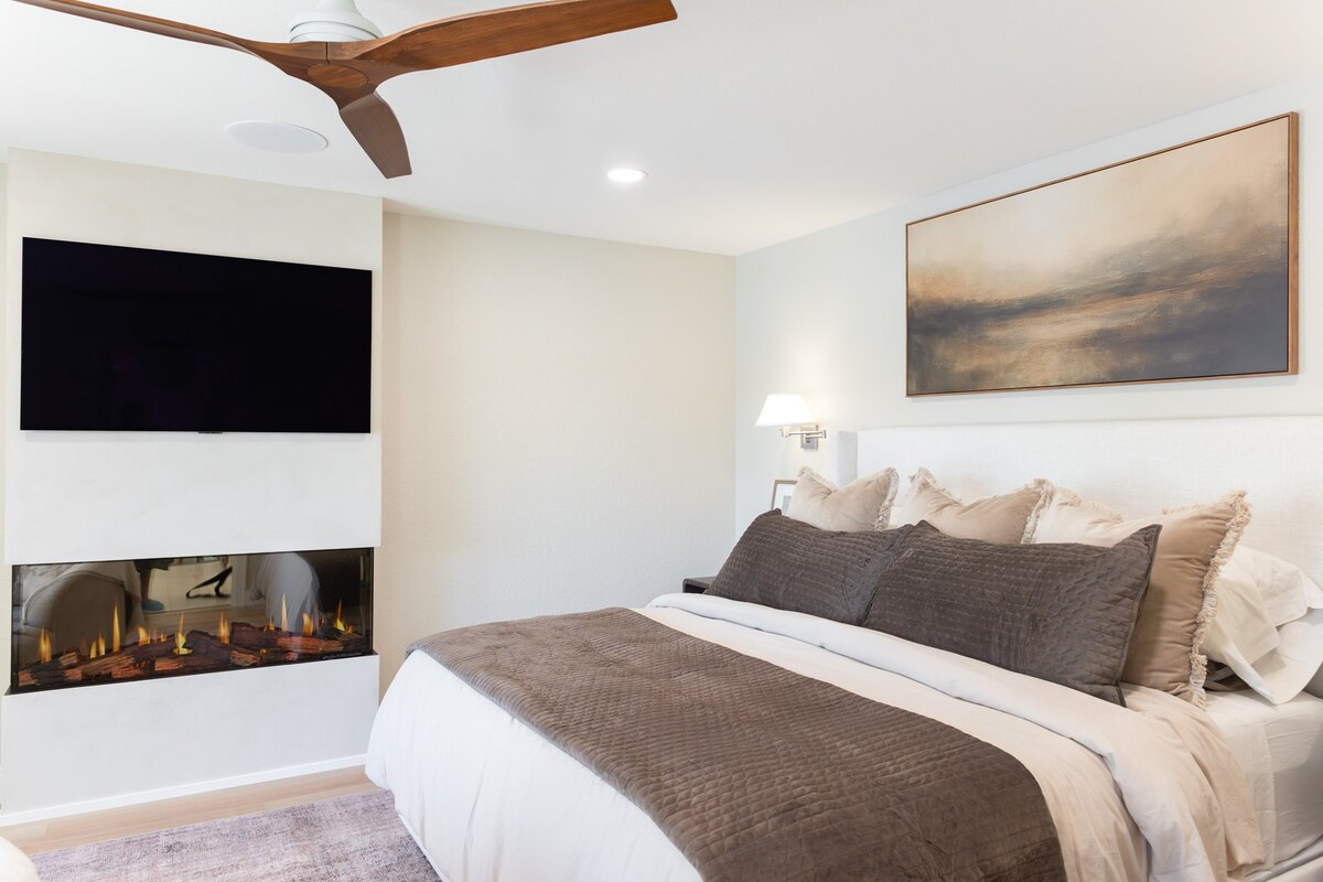 whole home remodel primary bedroom with linear fireplace and upholstered bed minocqua wi