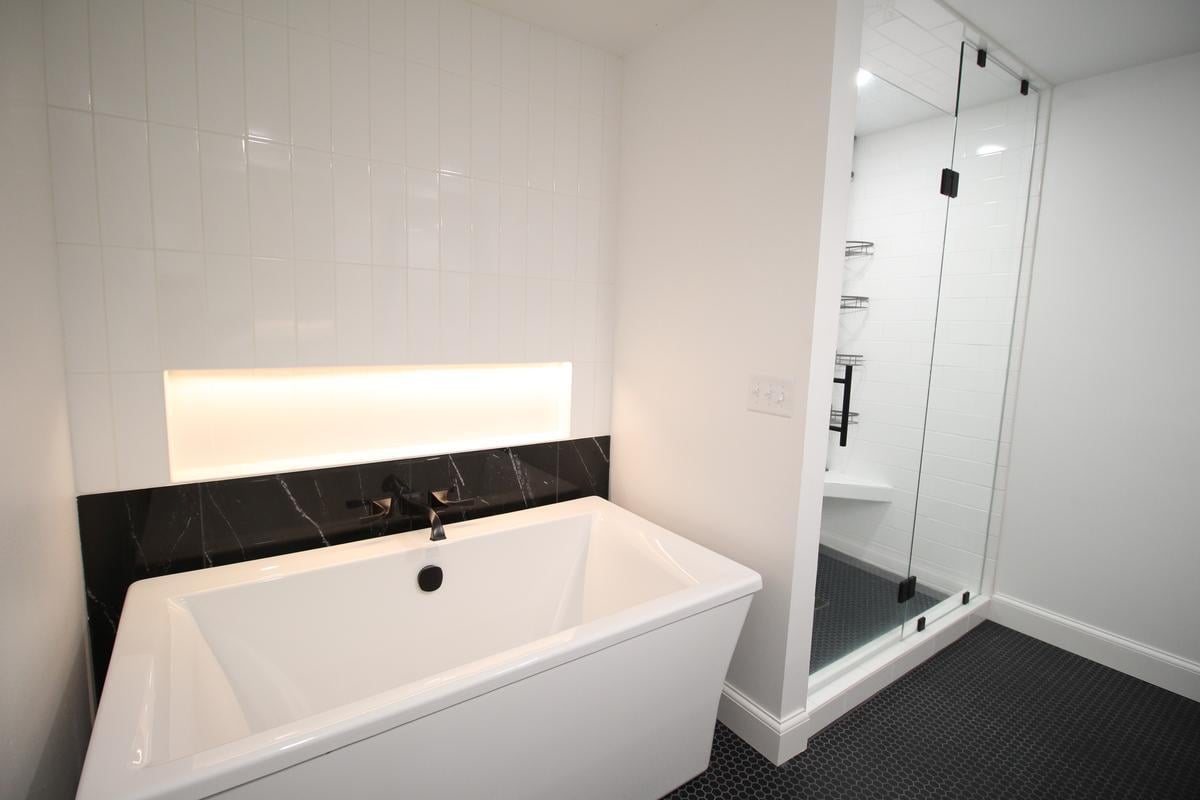 Contemporary bathroom with freestanding tub and LED accent lighting by Ross Construction in Rib Mountain, WI