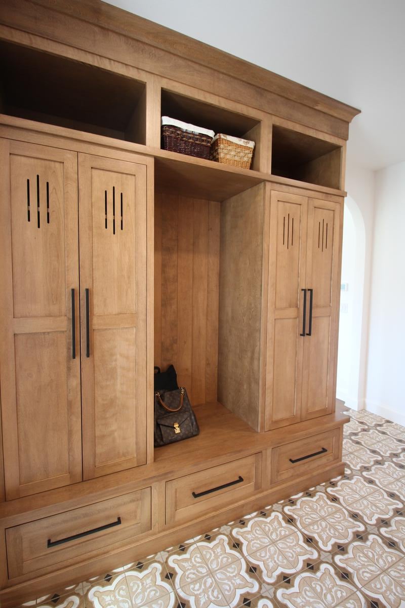 Custom mudroom cabinetry with wood lockers and decorative tile flooring by Ross Construction in Rib Mountain, WI