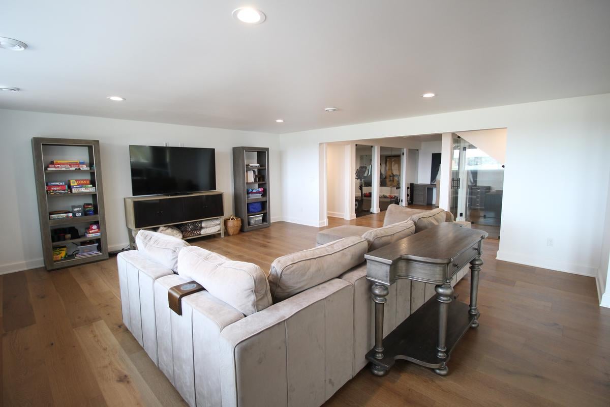 Family entertainment space with open layout and hardwood floors by Ross Construction in Marathon, WI