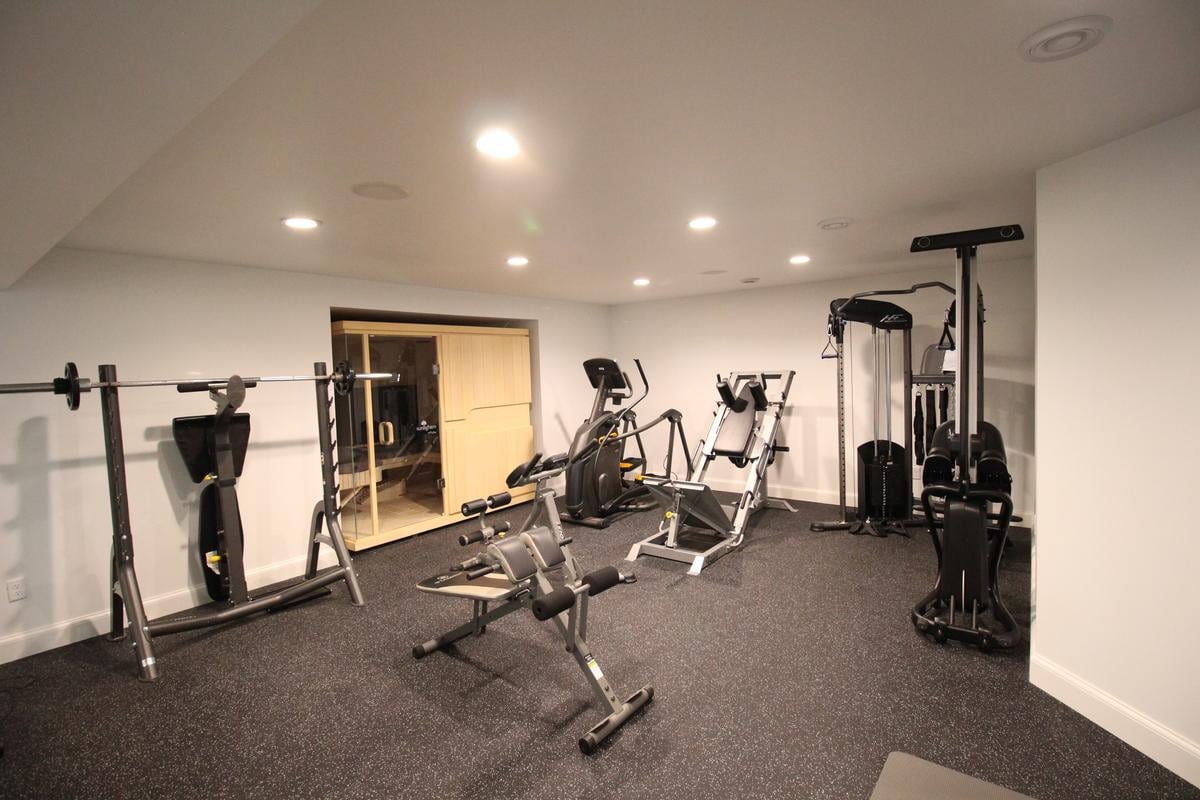 Fully equipped home gym with weight machines and personal sauna by Ross Construction in Marathon, WI