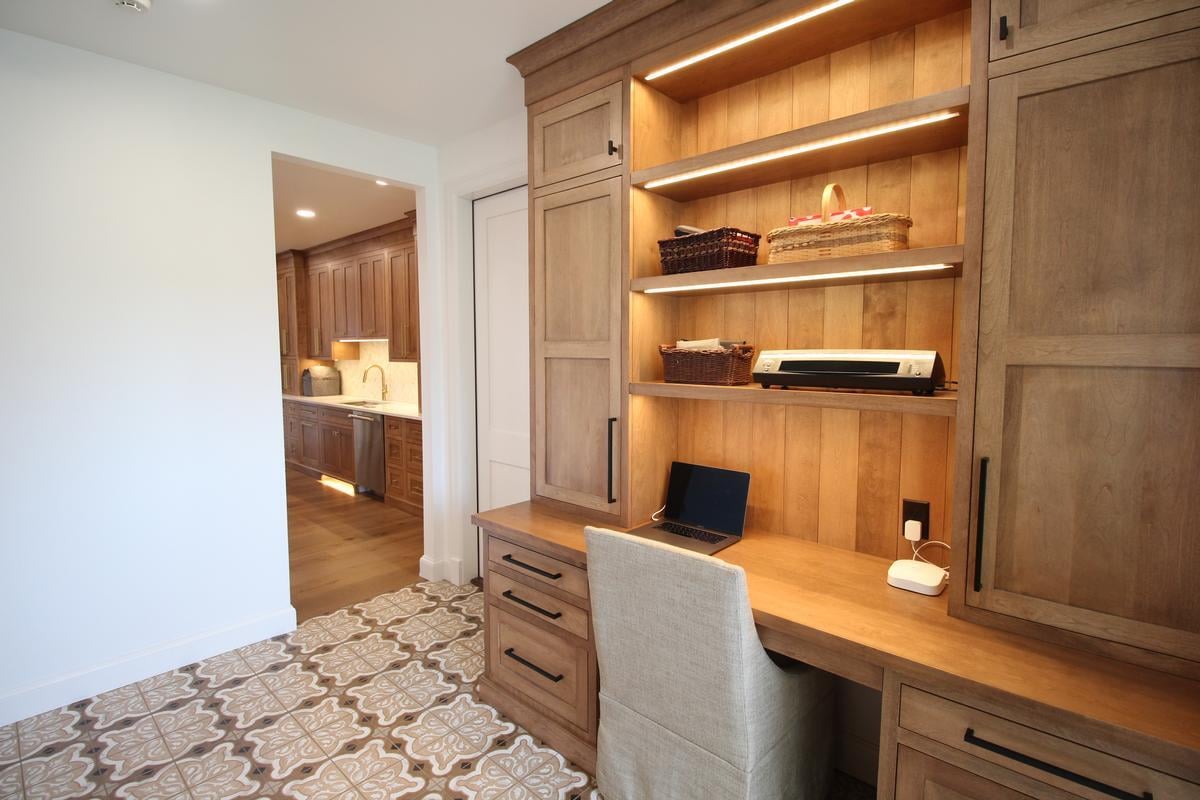Sleek white cabinetry and gold hardware in Ross Construction kitchen remodel in Rib Mountain, WI.