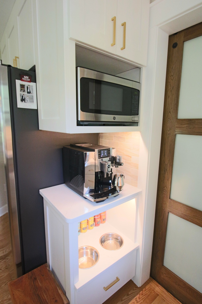 Compact kitchen coffee station with microwave and built-in pet drawers by Ross Construction in Lake Dubay, WI.