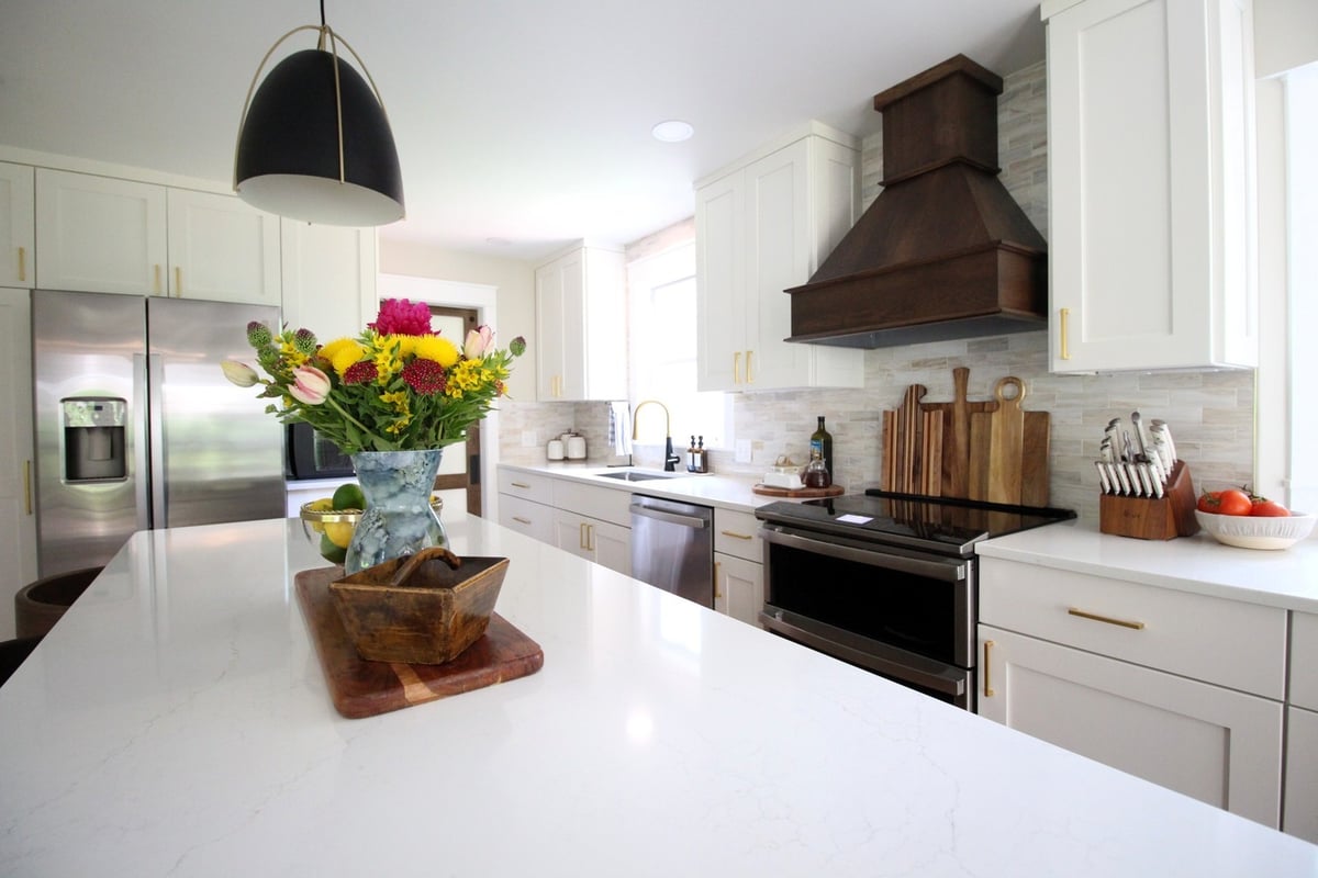 Floral centerpiece on large kitchen island with pendant lighting by Ross Construction in Rib Mountain, WI.
