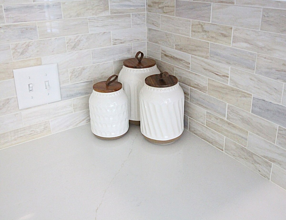 Kitchen corner detail featuring neutral tile backsplash and decorative jars in custom home by Ross Construction in Wausau, WI.