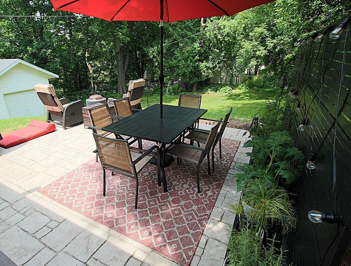 Stylish outdoor entertaining area with seating and rug by Ross Construction in Rib Mountain, WI.