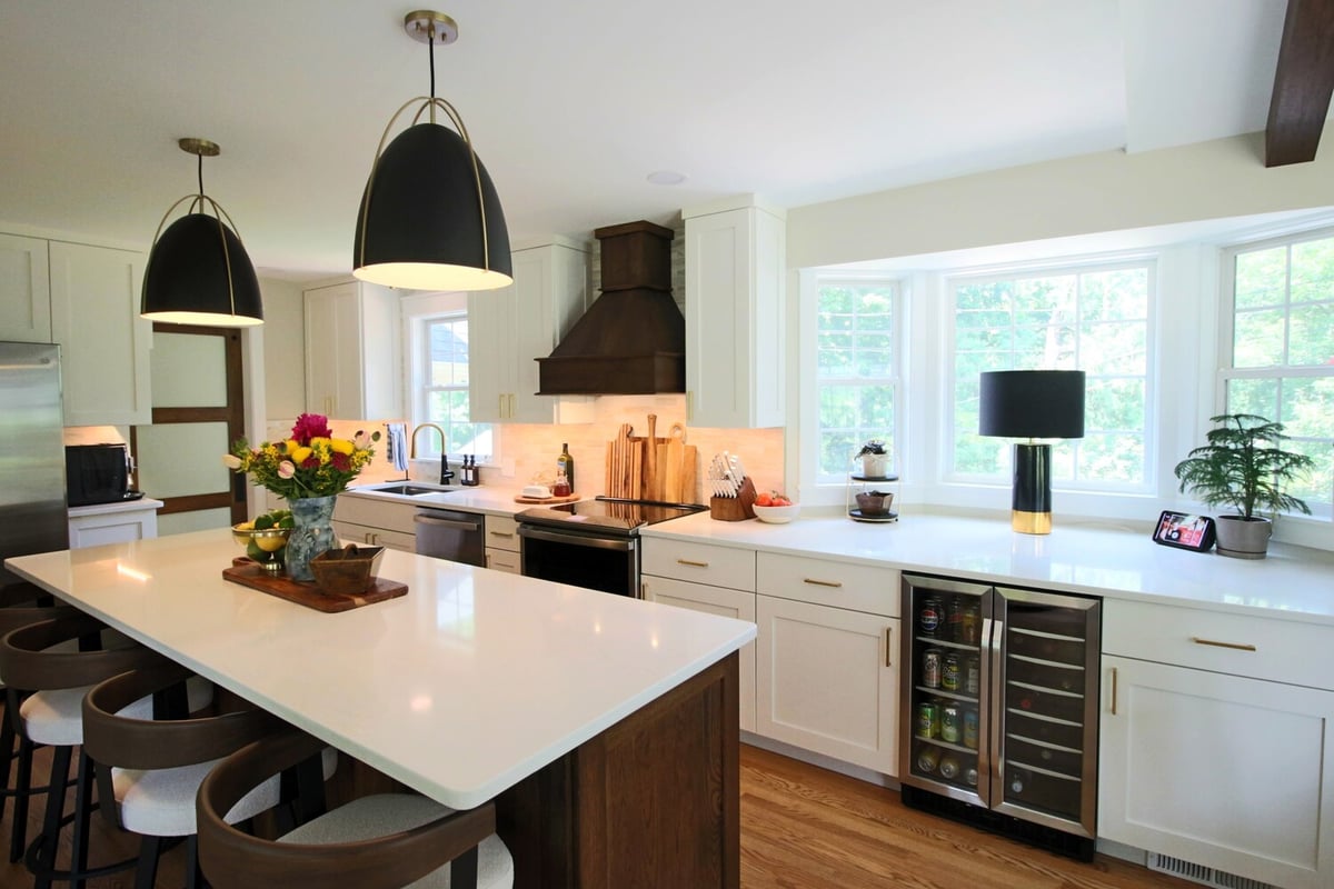 White kitchen with island seating and black pendant lights by Ross Construction in Wausau, WI.