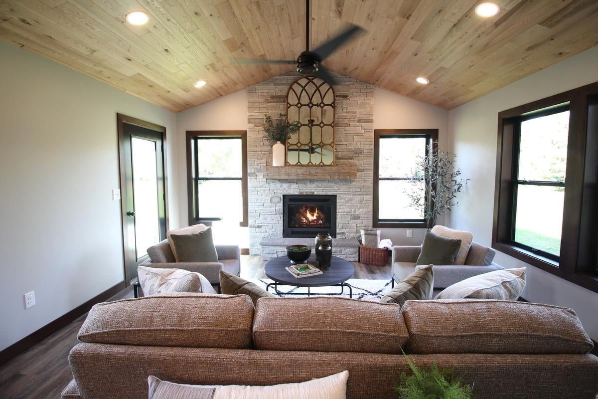 Custom-built sunroom by Ross Construction in Edgar, WI featuring wood ceiling and stone fireplace.