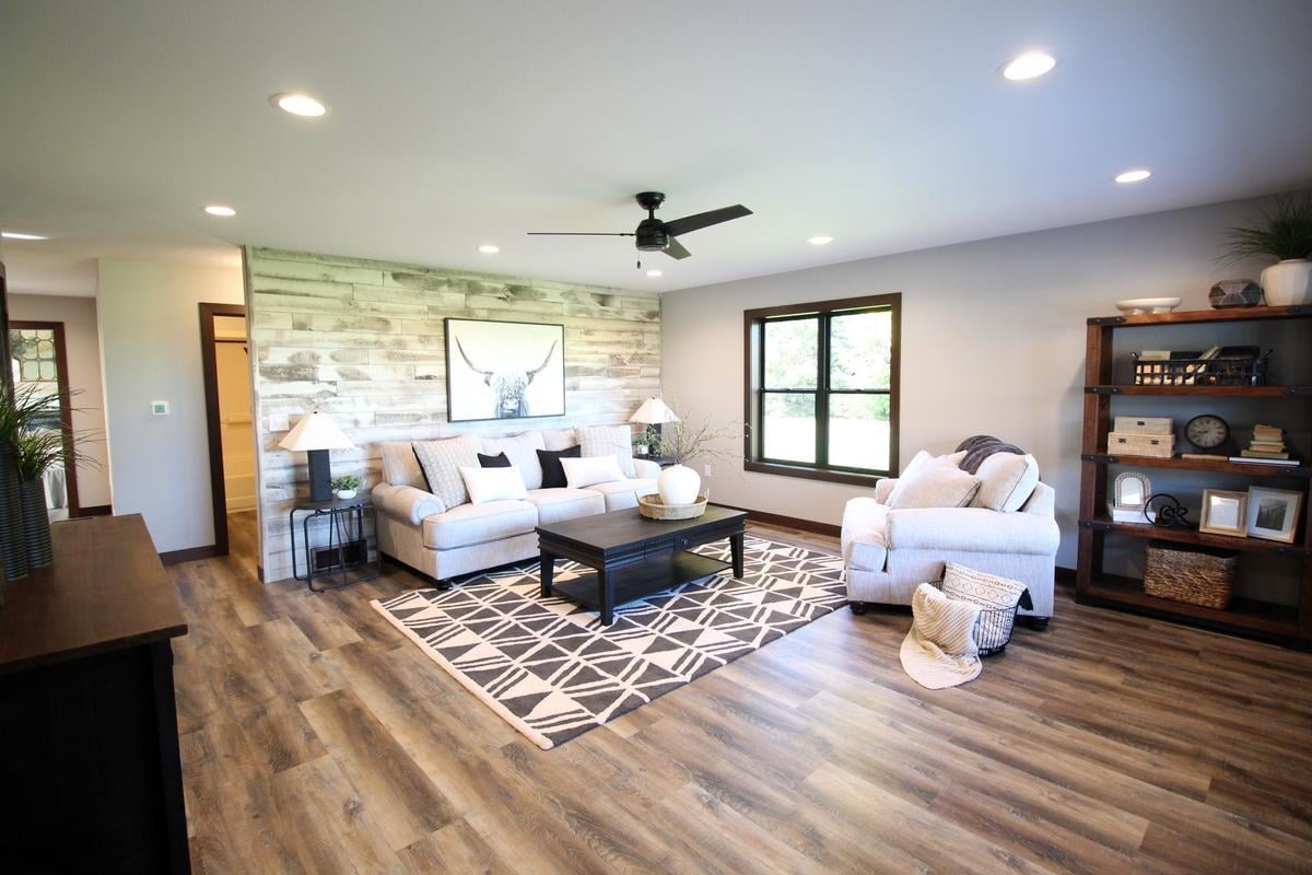 Modern farmhouse-style living room by Ross Construction in Wausau, WI featuring wood accent wall and natural lighting.