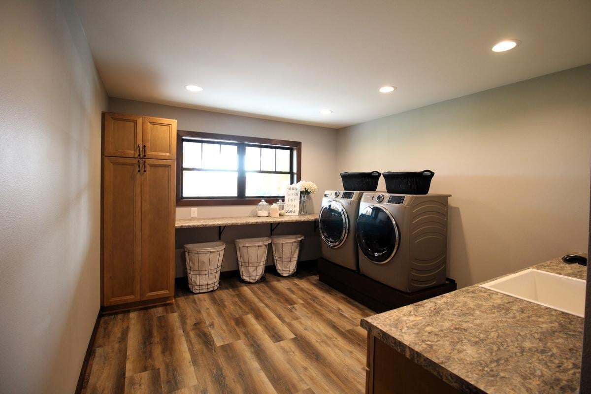 Spacious laundry room in Wausau, WI custom home by Ross Construction with front-load machines and storage.