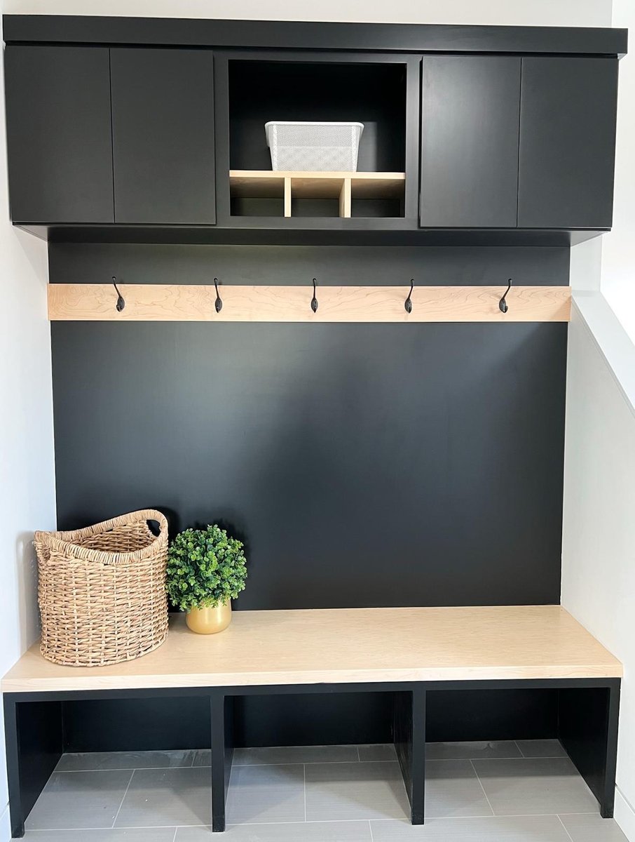 Custom mudroom by Ross Construction in Wisconsin featuring matte black cabinetry and wood accents.