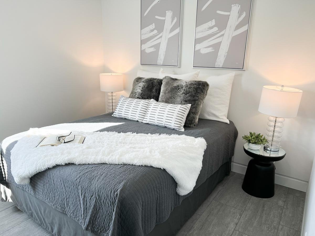 Lower level guest bedroom in Lake Dubay, WI custom home by Ross Construction with plush pillows and modern decor.